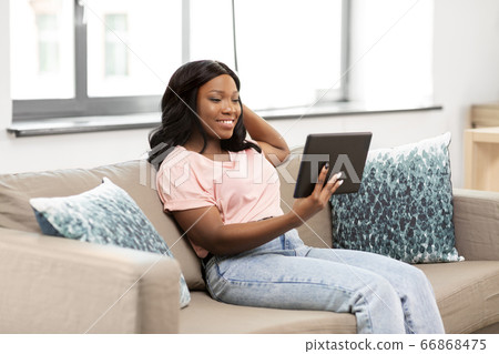 african american woman with tablet pc at home african american woman with tablet pc at home 66868475