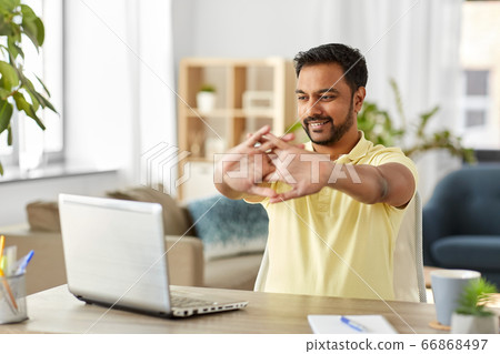 happy man with laptop stretching at home office happy man with laptop stretching at home office 66868497