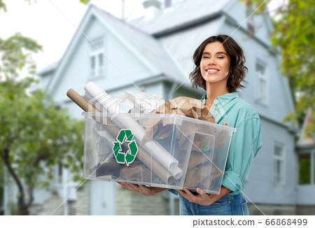 happy smiling young woman sorting paper waste happy smiling young woman sorting paper waste 66868499