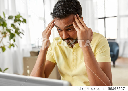 indian man with laptop working at home office 66868537