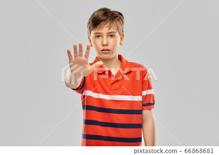 portrait of boy making stopping gesture 66868681