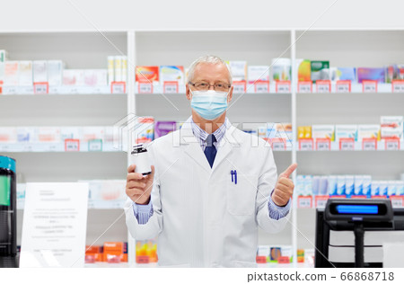 senior apothecary in mask with drug at pharmacy senior apothecary in mask with drug at pharmacy 66868718