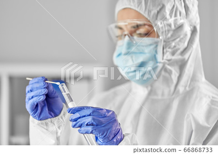 scientist holding beaker with coronavirus test 66868733