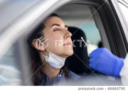 healthcare worker making coronavirus test at car healthcare worker making coronavirus test at car 66868798