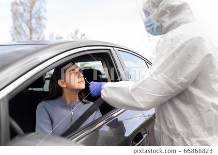 healthcare worker making coronavirus test at car 66868823