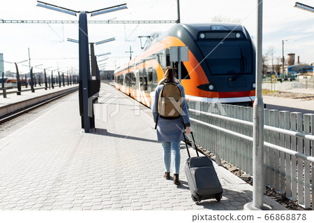 woman with travel bag on railway station woman with travel bag on railway station 66868878