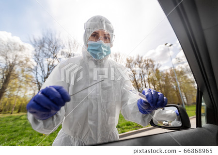 healthcare worker making coronavirus test at car 66868965