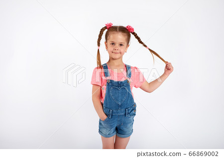 Cute small girl smailing and pulling her hair in the air, isolated on white background Cute small girl smailing and pulling her hair in the air, isolated on white background 66869002