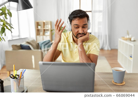 man in headphones with laptop working at home man in headphones with laptop working at home 66869044