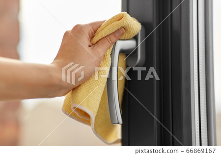 hand cleaning window handle with microfiber rag 66869167