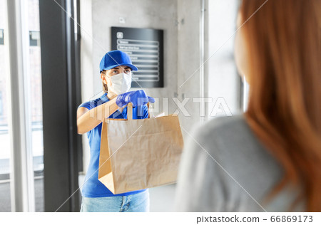 delivery girl in mask giving paper bag to customer delivery girl in mask giving paper bag to customer 66869173
