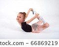 Little girl doing stretching and gymnastic exercises on a white background. 66869219