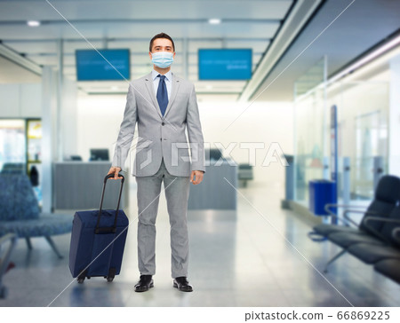 businessman in mask with travel bag at airport businessman in mask with travel bag at airport 66869225