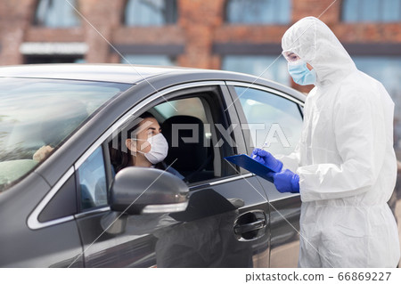 healthcare worker with clipboard and woman in car 66869227