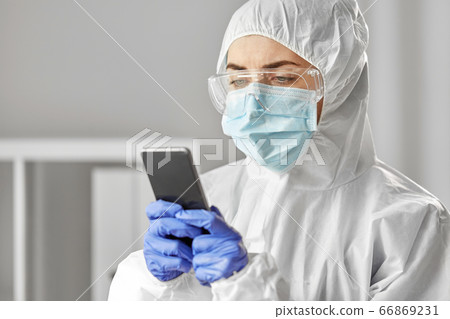 doctor in protective wear with smartphone doctor in protective wear with smartphone 66869231