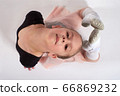 Little girl doing stretching and gymnastic exercises on a white background. 66869232