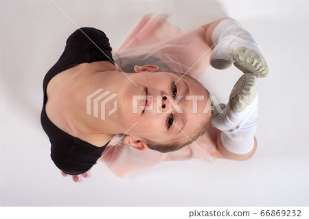 Little girl doing stretching and gymnastic exercises on a white background. Little girl doing stretching and gymnastic exercises on a white background. 66869232