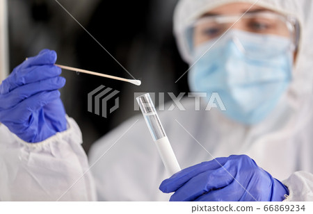 scientist holding beaker with coronavirus test scientist holding beaker with coronavirus test 66869234