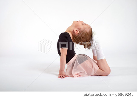 Little girl doing stretching and gymnastic exercises on a white background. 66869243