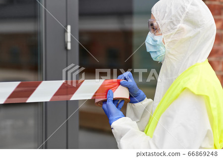 healthcare worker sealing door with caution tape 66869248