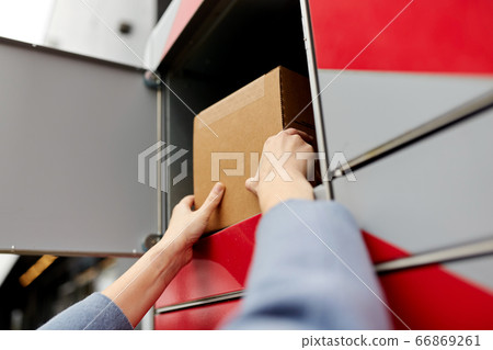 woman putting box to automated parcel machine woman putting box to automated parcel machine 66869261