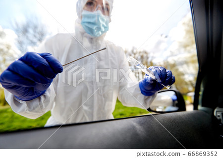 healthcare worker making coronavirus test at car healthcare worker making coronavirus test at car 66869352