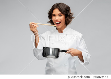 happy female chef with saucepan tasting food 66869434