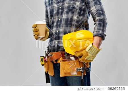 male builder with coffee, helmet and working tools 66869533