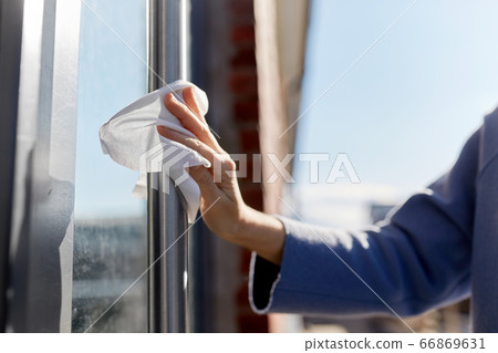 woman cleaning door handle with wet wipe woman cleaning door handle with wet wipe 66869631