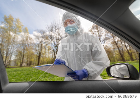 doctor in hazmat suit with clipboard at car doctor in hazmat suit with clipboard at car 66869679