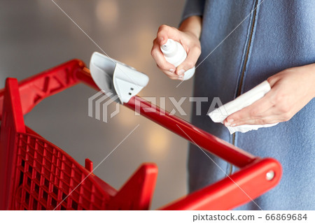 woman cleaning shopping cart handle with sanitizer woman cleaning shopping cart handle with sanitizer 66869684