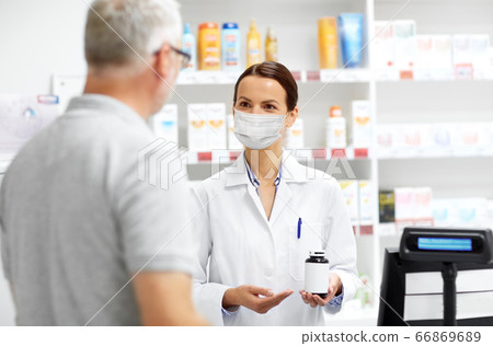 apothecary in mask and senior customer at pharmacy apothecary in mask and senior customer at pharmacy 66869689
