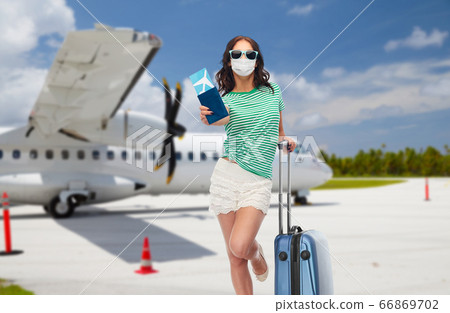 teen girl in mask with travel bag and air ticket teen girl in mask with travel bag and air ticket 66869702
