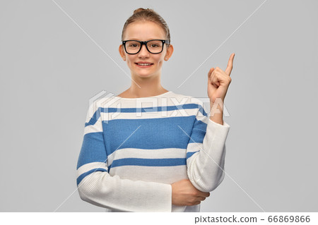 happy teenage girl in glasses pointing finger up happy teenage girl in glasses pointing finger up 66869866