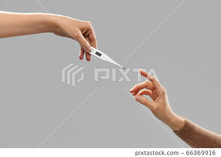 close up of hands giving each other thermometer close up of hands giving each other thermometer 66869916