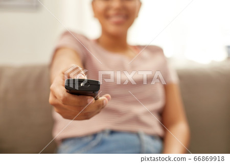 happy african american woman watching tv at home happy african american woman watching tv at home 66869918