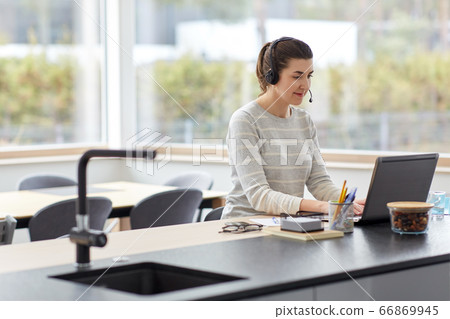 woman with headset and laptop working at home woman with headset and laptop working at home 66869945