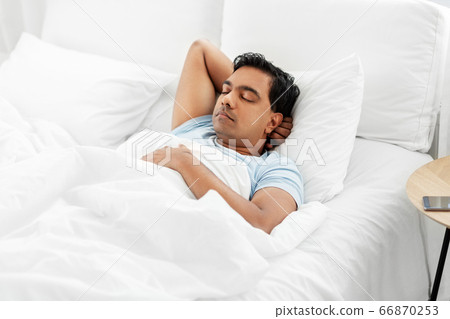 indian man sleeping in bed at home indian man sleeping in bed at home 66870253