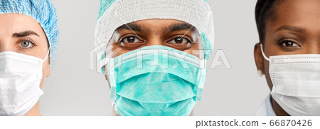 close up of doctor's faces in masks over grey close up of doctor's faces in masks over grey 66870426