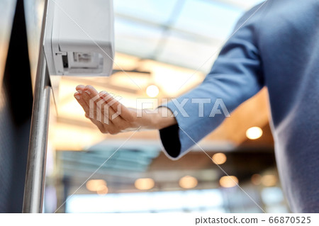 close up of woman at dispenser with hand sanitizer close up of woman at dispenser with hand sanitizer 66870525