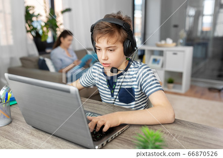boy with laptop and headphones at home boy with laptop and headphones at home 66870526