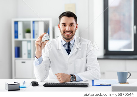 smiling male doctor with medicine at hospital smiling male doctor with medicine at hospital 66870544