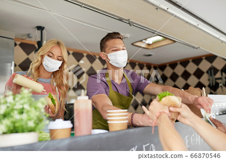 sellers in masks serving customers at food truck sellers in masks serving customers at food truck 66870546