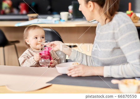 happy mother feeding baby with puree at home happy mother feeding baby with puree at home 66870550