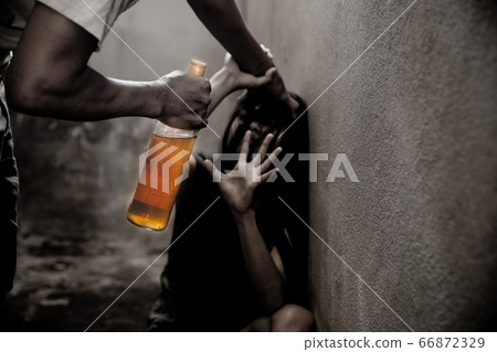 Woman victim of domestic violence and abuse. Woman scared of a man holding alcohol bottle. Woman victim of domestic violence and abuse. Woman scared of a man holding alcohol bottle. 66872329