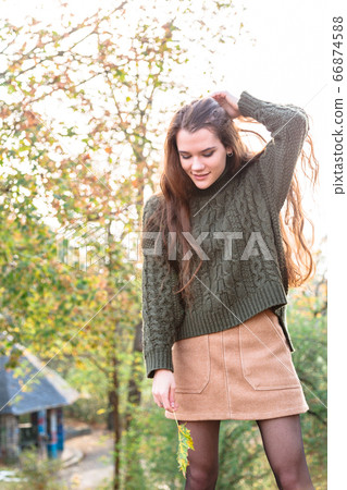 Girl on background of color trees straightens hair Girl on background of color trees straightens hair 66874588
