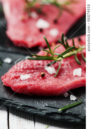Uncooked meat with rosemary and salt Uncooked meat with rosemary and salt 66874916