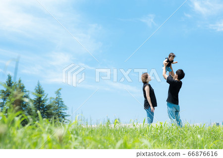 Family taking a walk with a baby under the blue sky 66876616