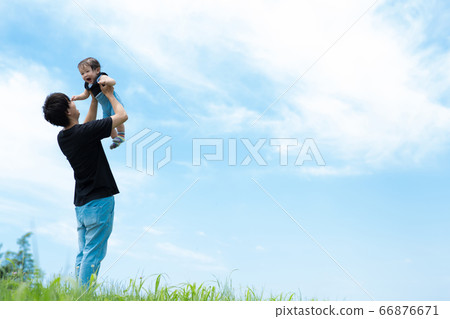 Daddy playing with a baby under the blue sky 66876671