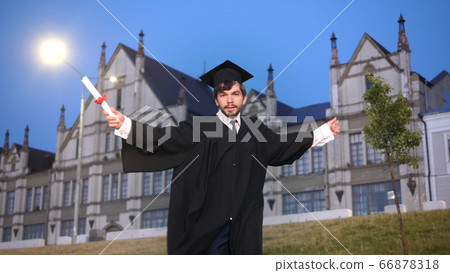 Male student in academic gown dancing. Male student in academic gown dancing. 66878318